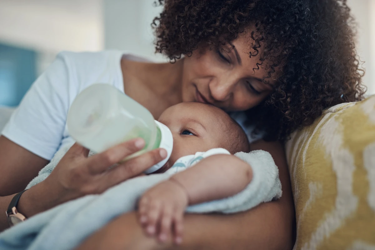 Image of a woman bottle feeding her baby